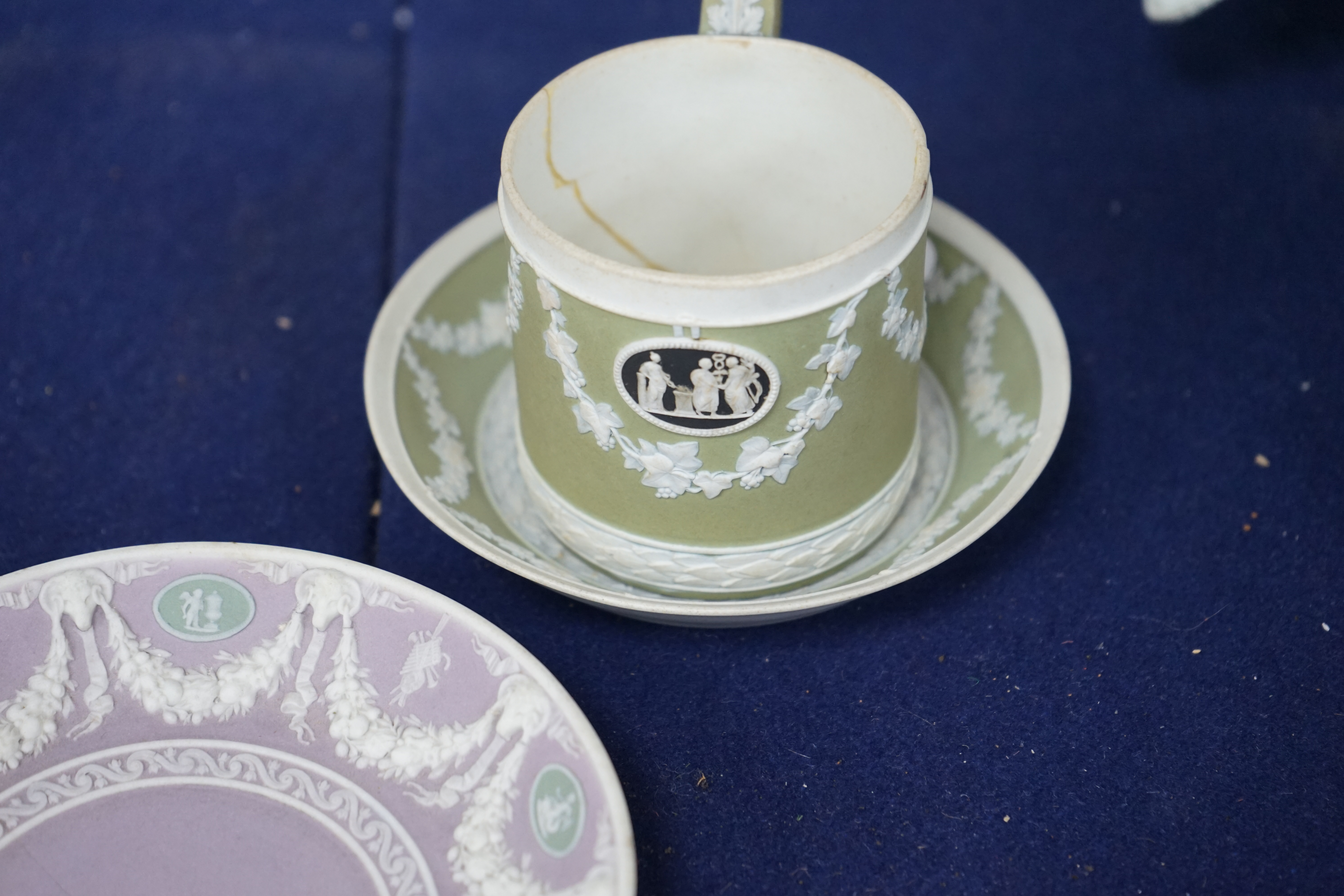 A Wedgwood three colour, green ground jasper cup and saucer and a single lilac ground saucer, early 19th century, 13.5cm. Condition - poor